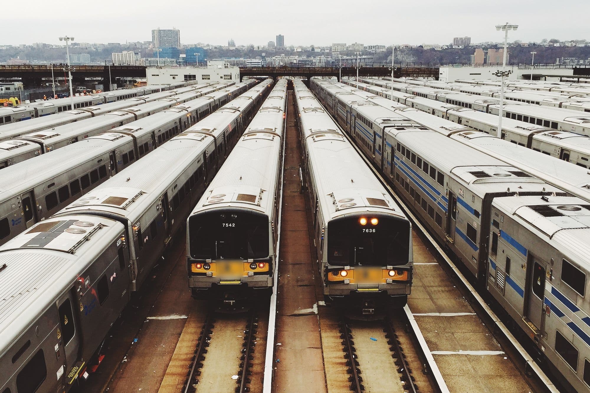Rows of parked commuter trains stabled side by side in a rail yard