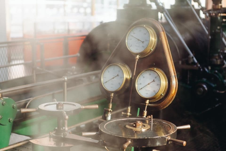 Brass pressure gauges and valve handwheels on steam plant machinery