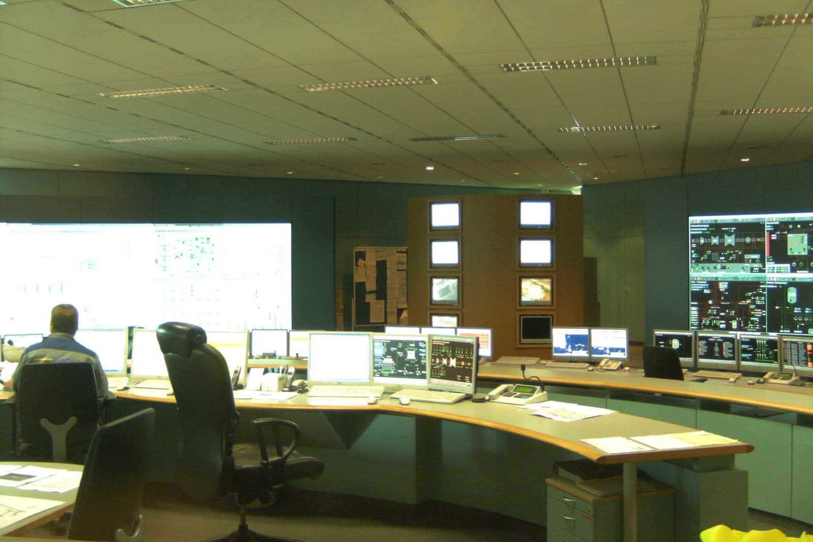 Power plant control room with operator desks, monitors and large wall displays